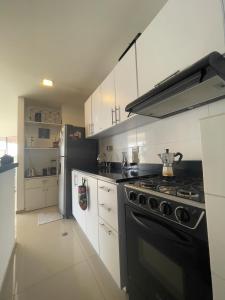 a kitchen with a black stove and white cabinets at Matilda apt - Feel at home in Barranquilla in Barranquilla