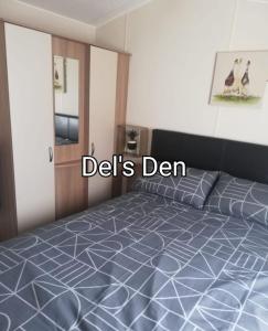 a bedroom with a bed with the words deliths den at Del's den lakeside weeley bridge in Weeley