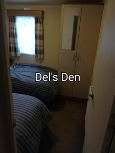 Schlafzimmer mit einem Bett, einem Fenster und einer Tür in der Unterkunft Del's den lakeside weeley bridge in Weeley