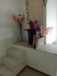 un conjunto de escaleras con flores en una habitación en Zia Ciccia en Marsala