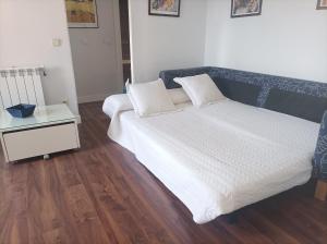 1 dormitorio con cama blanca y mesita de noche en Apartamento Pinar de Chamartin en Madrid