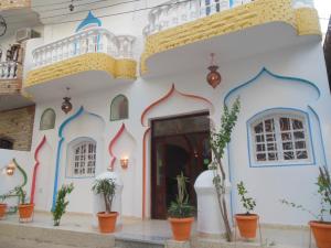 a white building with a door and potted plants at Cleopatra Hotel Luxor in Luxor