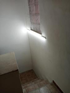 una habitación con una pared blanca con una luz en ella en Zia Ciccia en Marsala