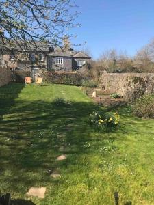 a large yard with a house in the background at Beaston Cottage in Totnes