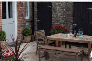 a wooden table and chairs on a patio at Beaston Cottage in Totnes