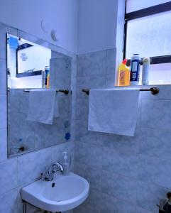 Baño blanco con lavabo y espejo en FLOZZY HOMES, en Kisumu