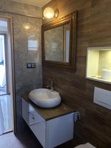 a bathroom with a sink and a mirror at Apartman "EXCLUSIVE" in Bihać