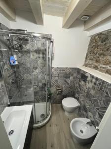 een badkamer met een douche, een toilet en een wastafel bij La mia deliziosa Casetta di giù in Termini Imerese