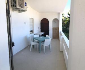 a dining room with a table and white chairs at Villa Dacla in Lampedusa