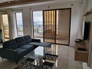 a living room with a couch and a glass table at FOUR IN ONE RESIDENTIAL HOMES in Limbe