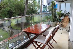 a balcony with a wooden table and chairs at PU4A Big Apt Overlooking Parque Urraca City Center in Panama City