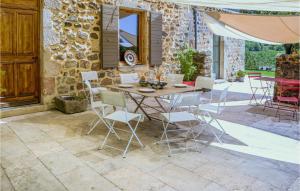 eine Terrasse mit einem Tisch, Stühlen und einer Steinmauer in der Unterkunft Lovely Home In St-etienne De Boulogne With Wifi in Saint-Étienne-de-Boulogne