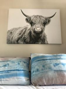 een schilderij van een koe met hoorns op een muur bij Logeren bij de bakker in Schiermonnikoog