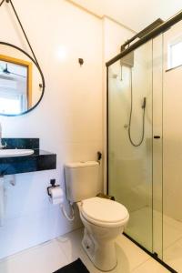 a bathroom with a toilet and a glass shower at Ap do Maro in Barreirinhas