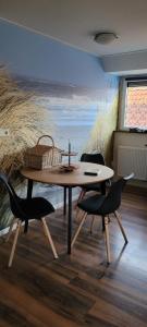een tafel en stoelen in een kamer met een schilderij bij Logeren bij de bakker in Schiermonnikoog