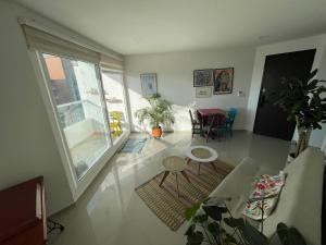 a living room with a large window and a table and chairs at Matilda apt - Feel at home in Barranquilla in Barranquilla