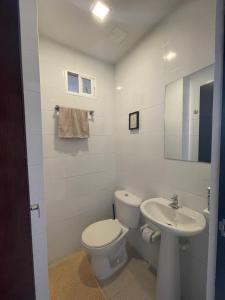een witte badkamer met een toilet en een wastafel bij Matilda apt - Feel at home in Barranquilla in Barranquilla