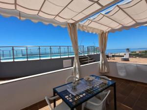 伊斯蘭蒂拉的住宿－islantilla vistas al mar 1 linea, piscina, parking, wifi，海景阳台上的桌子