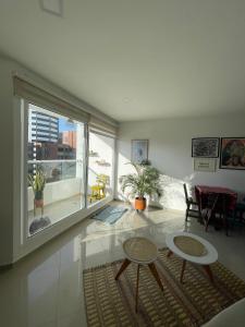 Matilda apt - Feel at home in Barranquilla في بارانكويلا: غرفة معيشة مع طاولتين ونافذة كبيرة