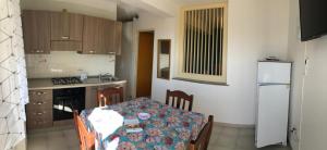 a small kitchen with a table and a refrigerator at Villa Dacla in Lampedusa