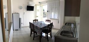 a kitchen with a table and chairs and a sink at Villa Dacla in Lampedusa