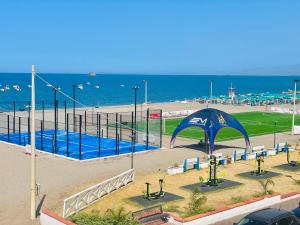 un parque con sombrilla azul junto a la playa en Case Eoliane, Alicudi, en Patti