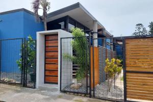 una casa azul con una puerta y una valla en Olly´s House, en Turrialba