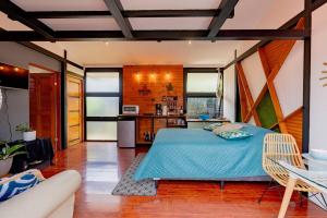 um quarto com uma cama azul e uma cozinha em Olly´s House em Turrialba