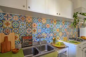 a kitchen with a sink and a tiled wall at Sea La Vie in Moneglia +11 photos