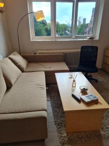 a living room with a couch and a coffee table at Private room in to roomsapartment (Grunneløkka) in Oslo