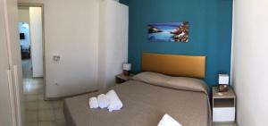 a bedroom with a bed with white slippers on it at Villa Dacla in Lampedusa