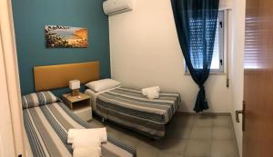 a small room with two beds and a window at Villa Dacla in Lampedusa