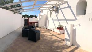 a pergola on the side of a white building at Villa Dacla in Lampedusa +37 photos