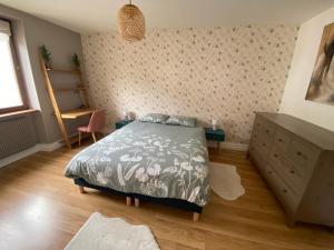 a bedroom with a bed and a dresser at Les brimbelles in Gérardmer