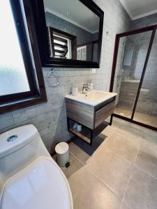 y baño con aseo, lavabo y espejo. en Tiny Loft House Santa Cruz, en Isla de Yaquil