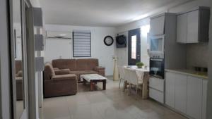 a kitchen and a living room with a couch and a table at באוירה יהודית in H̱azon