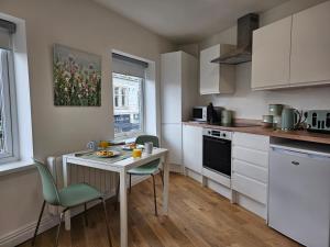 a kitchen with a table and chairs and a table and a counter at Charming 1-Bed Apartment in Cromer Town Centre in Cromer