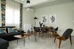 a living room with a couch and a table and chairs at City Chic Apartment in Volos