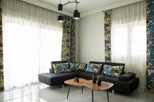 a living room with a black couch and a table at City Chic Apartment in Volos