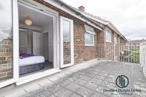 einen Balkon mit einem Bett und Glasschiebetüren in der Unterkunft Purple Velvet - 2 Bed Home Spacious - Basildon Essex Upto 5 Guests, Free Wifi , Free Parking in Basildon