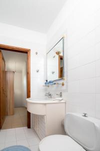 bagno con lavandino, servizi igienici e specchio di To Pyrgaki Kos a Città di Kos