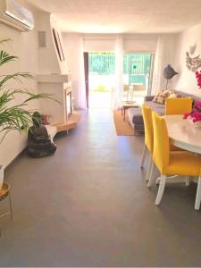 a living room with a table and yellow chairs at Seaside SunFlower in Quinta do Lago