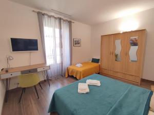 Cette chambre comprend un lit, un bureau et une télévision. dans l'établissement CASA DI ARTISTI AJACCIO - Holiday Homes - Classé 5 étoiles - EXCEPTIONNEL, à Ajaccio