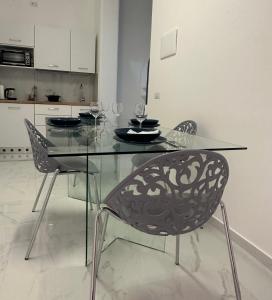 a glass dining table and chairs in a kitchen at Il Cerriglio Holiday Home Massa Lubrense - Sorrento coast in Massa Lubrense