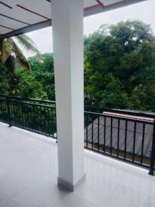 balcón con vistas al agua y a los árboles en Oasis Suite, en Kandy