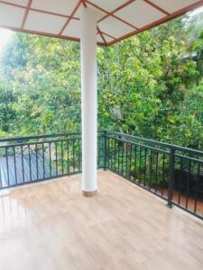 balcón con barandilla negra y árboles en Oasis Suite, en Kandy