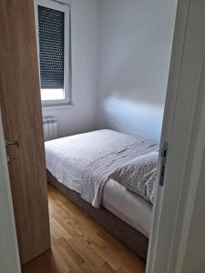 a small bedroom with a bed and a window at Apartman Una banjaluka in Hiseti