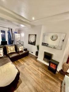 a living room with a couch and a fireplace at The Princes Dartford Stunning Entire Space in Kent