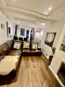uma sala de estar com um sofá de couro e uma lareira em The Princes Dartford Stunning Entire Space em Kent