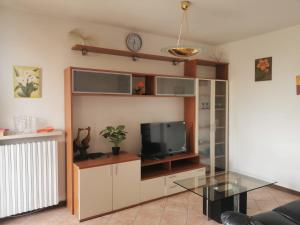 een woonkamer met een tv en een glazen tafel bij Serenity Home in Posta Vecchia